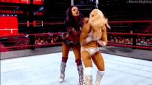 two women are wrestling in a wrestling ring and one of them is wearing a mask .