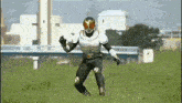 a man in a superhero costume is standing in a field giving a thumbs up .