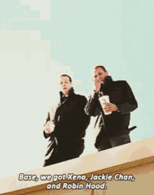 two men standing on top of a building with the words base we got xena jackie chan and robin hood below them