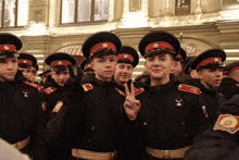 a group of soldiers are posing for a photo and one of them is giving the peace sign