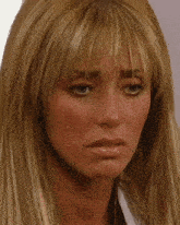 a close up of a woman 's face with long blonde hair