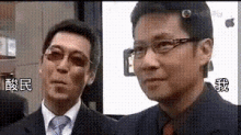a man in a suit and tie is standing next to another man in a suit and tie .