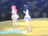 two anime girls are dancing on a stage in front of a crowd .