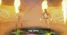 two wrestlers are standing in front of a banner that says the opps on it