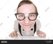 a nerd with a bandage on his nose is typing on a keyboard