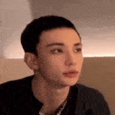 a young man with a shaved head is looking at the camera .