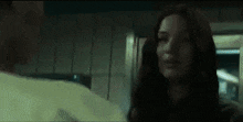 a woman is standing next to a man in a dark room .