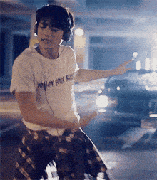 a man wearing headphones and a t-shirt that says no more rules is dancing