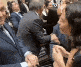 a man in a suit and tie is shaking hands with a woman