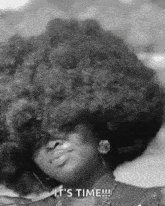 a black and white photo of a woman with an afro and the words `` it 's time '' .
