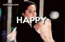 a woman is dancing with the words `` happy '' written on her face .