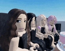 a group of girls are sitting next to each other with a cake in the background