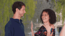 a man and a woman are standing next to each other and the woman is smiling