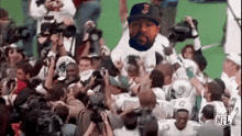 a man in a hat is being lifted in the air by a group of people .