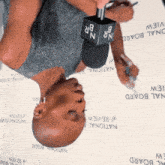 a man is upside down holding a microphone with the letter n on it
