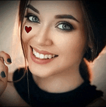 a close up of a woman 's face with a heart on her face .