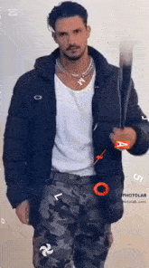 a man wearing a black jacket and camo pants is holding a red a sign