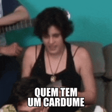 a woman sitting on a couch with the words quem tem um cardume written on her face