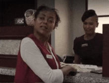 two women are standing at a counter with a sign that says fdic on it