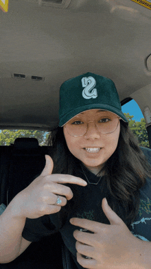 a woman wearing a green hat with the letter 2 on it