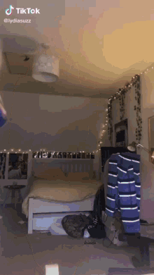 a bedroom with a bed and a blue and white striped shirt that says tik tok