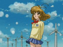 a girl is standing in front of windmills in a field