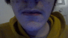 a close up of a person 's face with a yellow hoodie on