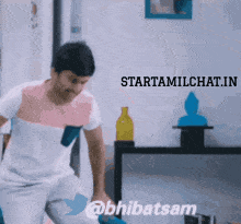 a man is standing in a room with the words starttamilchat.in