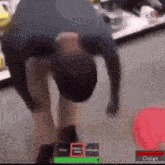 a man is bending over in a video game with a red button that says charge .