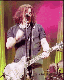 a man is playing a guitar and singing into a microphone with the words girlwithbot on the bottom