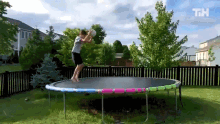 a boy is jumping on a trampoline with the letters th on the bottom right