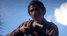 a man wearing a mask holds a gun in his hand