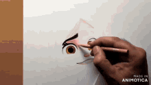a person is drawing a face with a pencil and the words made in animotica are visible