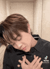 a tiktok video of a young man with his hands on his heart