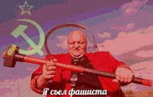 a man in a red suit is holding a large hammer in front of a hammer and sickle .