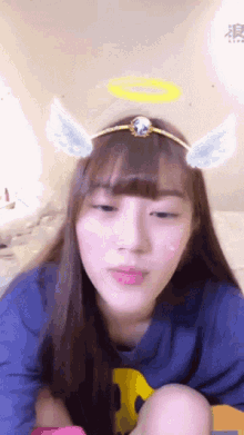 a girl wearing a headband with angel wings and a halo around her head