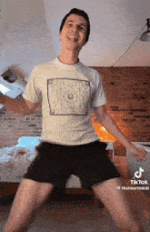a man wearing a t-shirt with a square on it is dancing