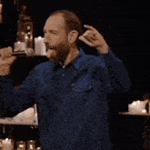 a man singing into a microphone with candles behind him