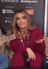 a woman playing a guitar in front of a sign that says novartis