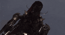 a statue of a warrior with a red cape and skulls on his arms