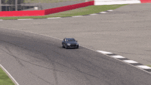 a car is driving on a race track with a sign that says ' coca cola ' on it
