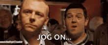 two men are standing next to each other in a crowd and one of them is saying jog on .