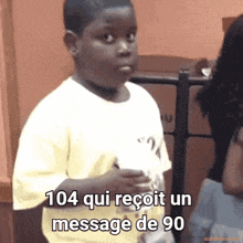 a young boy is holding a piece of paper with the words 104 qui reçoit un message de 90 on it