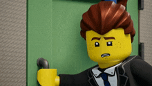 a lego man in a suit and tie is standing in front of a door