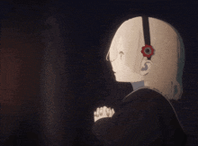 a girl with a flower in her hair is praying in the dark