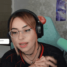 a woman wearing glasses and headphones sits in a chair that says " gigante "