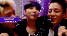three men are standing next to each other with a sign that says toppdogg behind the show