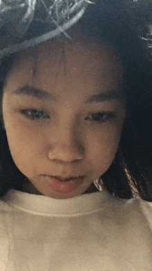 a close up of a girl 's face with a white shirt