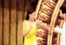 a woman in a yellow dress is talking to a man