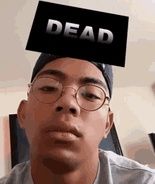 a man wearing glasses and a hat with a dead sign on his head